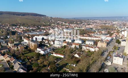 Aus der Vogelpernay, Frankreich, mit einem Wohnviertel, städtischen Straßen und umliegenden Weinbergen unter einem klaren blauen Himmel. Stockfoto