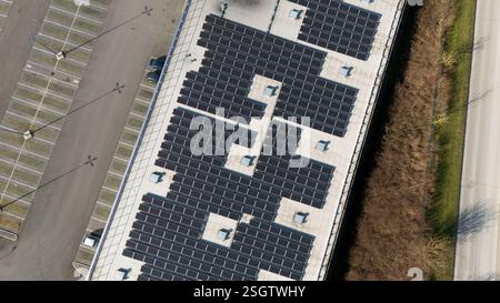 Detaillierte Luftaufnahme eines Dachs in Epernay, Frankreich, mit einem Gitter aus Solarpaneelen, angrenzenden Parkplätzen und einer nahegelegenen Straße. Stockfoto