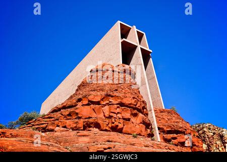 Großer Felsen mit einem Kreuz darauf. Das Kreuz besteht aus Beton. Der Felsen liegt auf einem Hügel Stockfoto