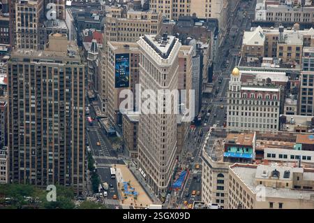 Blick aus der Vogelperspektive auf das berühmte Flatiron Building in New York City, umgeben von belebten Straßen, gelben Taxis und historischer Architektur Stockfoto