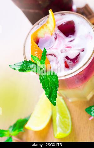 Erfrischendes Sommergetränk mit Pfefferminz-, Limetten- und Orangengarnituren in sonniger Umgebung im Freien Stockfoto