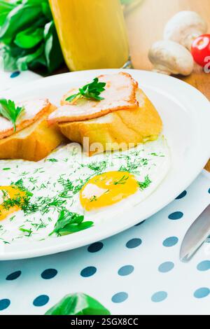 Frühstücksteller mit Eiern, Toast und frischen Beilagen auf einem Holztisch Stockfoto