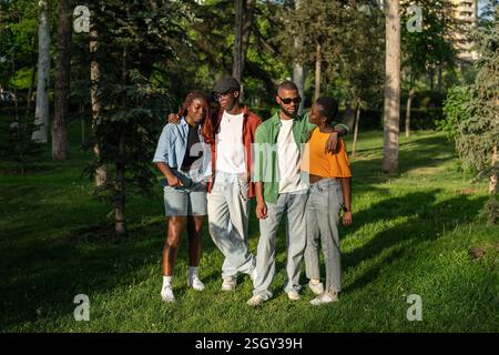 Junge, multirassische Freunde reisen zusammen, stehen und posieren für die Kamera in Parkwäldern Stockfoto