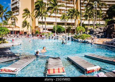 Honolulu, Hawaii - USA - 30. August 2018: Sonnenanbeter liegen am Luxus-Resort-Pool des Royal Hawaiian Resort. Stockfoto