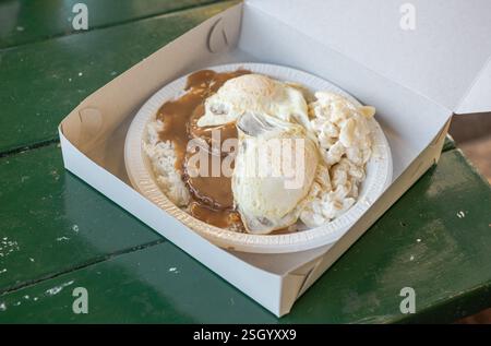 Loco Moco Teller - ein hawaiianisches Gericht mit gedämpftem Reis, Hamburger-Patty, brauner Soße und einem Spiegelei - serviert in einer Papierkarton im legendären Rainbow Drive-in. Stockfoto