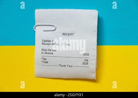Eine Quittung aus einem Geschäft mit dem Text Stop the war in Ukraine und anstelle des Betrags, den das Jahr 2025 geschrieben wird, liegt die Quittung auf der Flagge der Ukraine Stockfoto