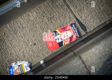 Berlin, Deutschland. Februar 2025. Neben den Straßenbahngleisen in Berlin liegt ein verworfenes SPD-Wahlblatt mit dem heutigen Bundeskanzler Olaf Scholz. Dieses Bild symbolisiert die rückläufige Popularität von Scholz und seiner Partei in den letzten fünf Jahren. Stockfoto