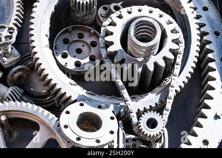 Hintergrund Metallgetriebe. Alte und rostige Ersatzteile für Industriemaschinen auf Deponien. Stockfoto