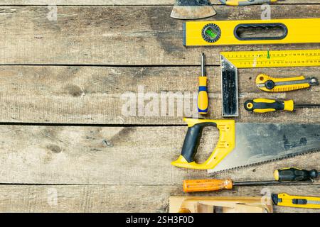 Auf einer Holzoberfläche angeordnete Werkzeuge für Bau- und Heimwerkerprojekte in einer Werkstattumgebung Stockfoto