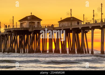 Der dramatische Himmel aus dem Rauch des Waldfeuers umgibt den Pier in Huntington Beach Kalifornien und bietet einen einzigartigen Sonnenuntergang über das berühmte Reiseziel. Stockfoto