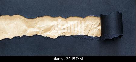 Zerknitterter brauner Papierstreifen unter schwarzem Papier mit gewellten Kanten, die einen Kontrast zum Text schaffen. Stockfoto