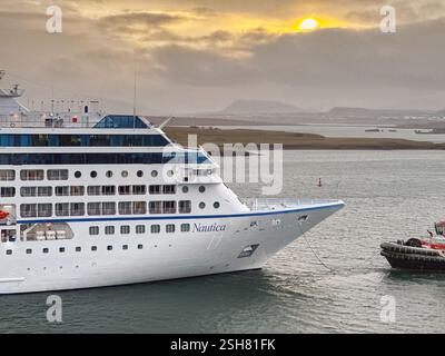 Reykjavík, Island - 22. August 2024: Das Kreuzfahrtschiff Nautica wird am frühen Morgen von einem Schlepper in den Hafen gebracht. Das Schiff wird von Ozeanien betrieben. Stockfoto