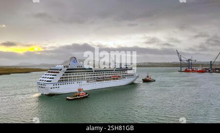 Reykjavík, Island - 22. August 2024: Das Kreuzfahrtschiff Nautica wird am frühen Morgen von einem Schlepper in den Hafen gebracht. Das Schiff wird von Ozeanien betrieben. Stockfoto