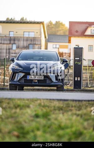 Elektroauto wird bei sonnigem Wetter an einer Ladestation aufgeladen, E-Car-Sharing-Fahrzeug von Deer Mobility, Gechingen, Schwarzwald, Deutschland, Europa Stockfoto