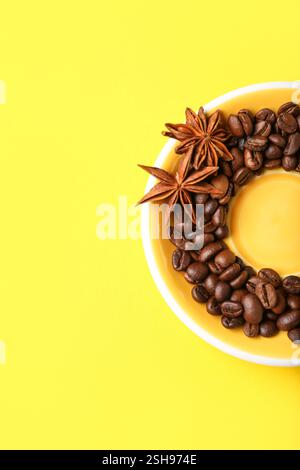 Rahmen aus Kaffeebohnen und Sternanis auf gelbem Hintergrund Stockfoto