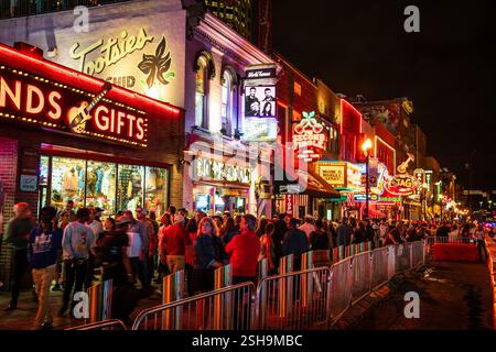 13. Oktober 2023, Nashville, TN: Menschenmassen laufen entlang der Broadway Street, beleuchtet durch berühmte Neonschilder bei Nacht Stockfoto
