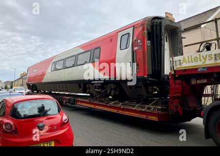 Ein BR Mark 4 Passagierwagen auf einem Tieflader, der nach dem Verlassen des Landore Depots durch das Hafod in Swansea gefahren wird. Oktober 2023. Stockfoto