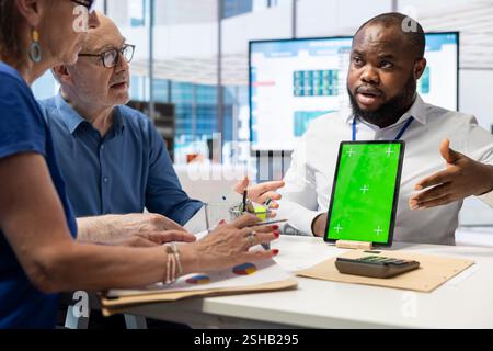 Senioren, die professionelle finanzielle Beratung zur Altersvorsorge erhalten und neben der Anzeige von Kopierflächen auf dem Tablet diskutieren. Gewährleistung der Sicherheit von Lebensersparnissen und der Rentenoptionen. Stockfoto