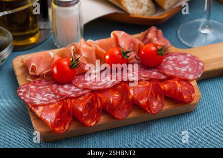 Spanische leckere Mahlzeit Würste und Jamon mit Tomaten schneiden, Nahaufnahme Stockfoto