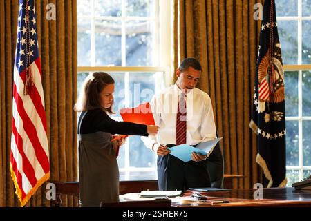 Präsident Barack Obama sieht tägliche Korrespondenz im Oval Office mit seiner persönlichen Sekretärin Katie Johnson 30.01.09. Offiziellen White House Photo by Pete Souza Stockfoto