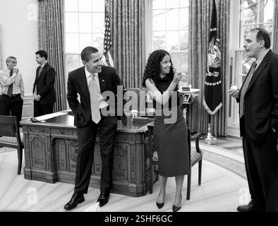 Präsident Barack Obama Witze mit senior Berater Mona Sutphen und David Axelrod während einen Geburtstag feiern 15. April 2009, senior Advisor Pete Rouse. Oval Office. Offiziellen White House Photo by Pete Souza Stockfoto