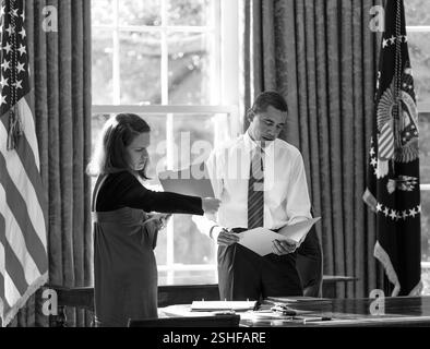 Präsident Barack Obama sieht tägliche Korrespondenz im Oval Office mit seiner persönlichen Sekretärin Katie Johnson 30.01.09. Offiziellen White House Photo by Pete Souza Stockfoto