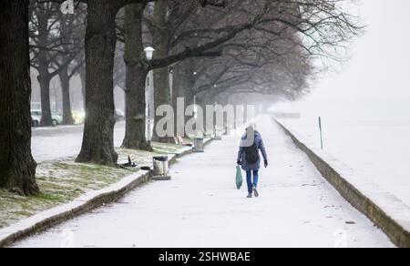 Hannover, Deutschland. Februar 2025. Eine Frau läuft am schneebedeckten Ufer des Maschsees entlang. Quelle: Julian Stratenschulte/dpa/Alamy Live News Stockfoto
