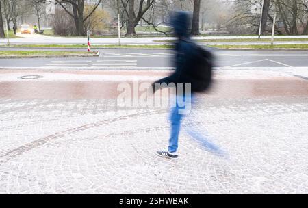 Hannover, Deutschland. Februar 2025. Ein Mann läuft auf einem schneebedeckten Gehweg. Quelle: Julian Stratenschulte/dpa/Alamy Live News Stockfoto