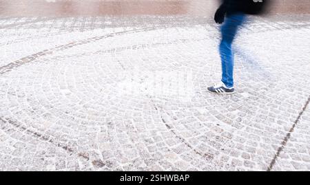Hannover, Deutschland. Februar 2025. Ein Mann läuft auf einem schneebedeckten Gehweg. Quelle: Julian Stratenschulte/dpa/Alamy Live News Stockfoto