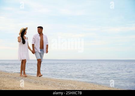 Schönes Paar, das am Strand spaziert. Platz für Text Stockfoto