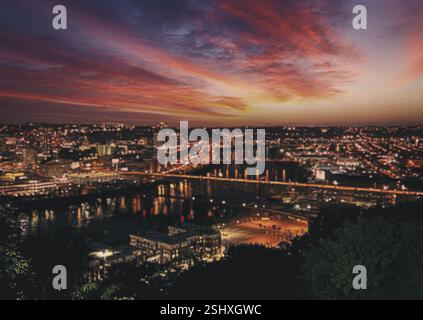 Skyline von Pittsburgh, Pennsylvania, USA bei Sonnenaufgang. Skyline der Stadt bei Nacht mit einem wunderschönen Sonnenuntergang im Hintergrund. Die Stadt ist beleuchtet mit Lichtern und dem Stockfoto