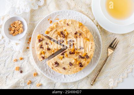 Gesalzener Karamell-Käsekuchen mit einer Tasse Tee Stockfoto