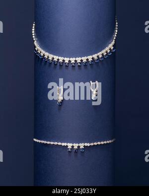 Minimalistisches Spiralschmuck-Set mit Halskette und Ohrringen mit einzigartigem Wirbel-Design vor leuchtendem blauem Hintergrund Stockfoto