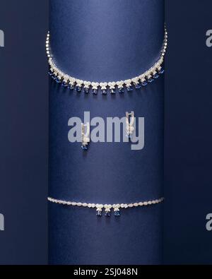 Minimalistisches Spiralschmuck-Set mit Halskette und Ohrringen mit einzigartigem Wirbel-Design vor leuchtendem blauem Hintergrund Stockfoto