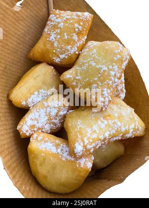 Schmalzkuchen, Schmalzkuchen vom Weihnachtsmarkt in Deutschland. Deutsche Fingerfood-Spezialität. Gebratenes Gebäck aus Hefeteig mit Puderzucker. Stockfoto