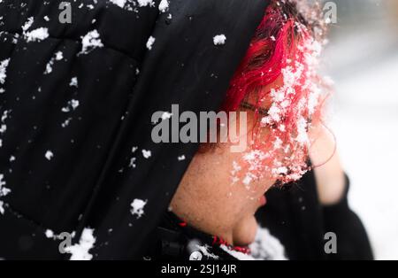 Hannover, Deutschland. Februar 2025. Schneeflocken hängen in rot gefärbten Haaren, wenn es schneit. Quelle: Julian Stratenschulte/dpa/Alamy Live News Stockfoto