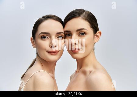 Zwei atemberaubende Schwestern mit strahlendem Lächeln posieren aus nächster Nähe und zeigen ihre Schönheit und Verbundenheit. Stockfoto