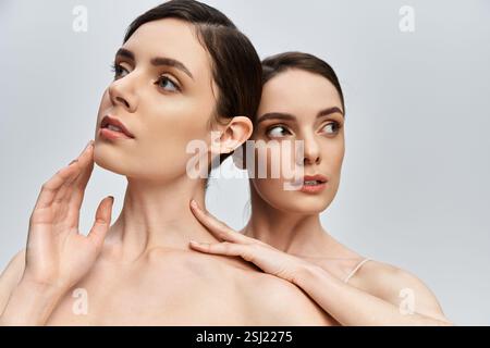 Elegante Zwillingsschwestern posieren nachdenklich und zeigen ihre enge familiäre Bindung. Stockfoto