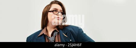 Eine Frau in Übergröße mit Brille zeigt ihren einzigartigen Stil, während sie drinnen eine selbstbewusste Pose zeigt. Stockfoto