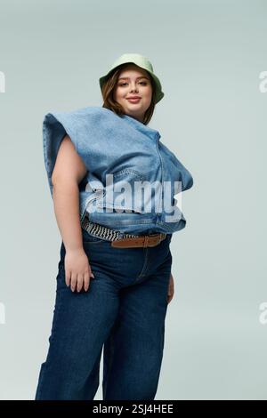 Eine junge Frau in Übergröße zeigt stolz ihren einzigartigen Stil mit einem Denim-Outfit. Stockfoto