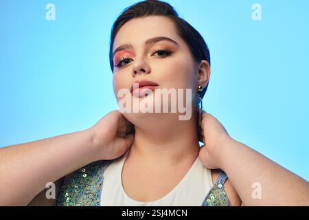Eine wunderschöne junge Frau zeigt ihren Stil und ihr Selbstvertrauen mit einer verspielten Pose und einem atemberaubenden Make-up. Stockfoto