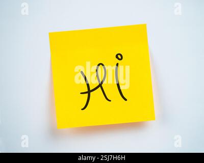 Eine hellgelbe Haftnotiz zeigt das Wort Hi in einer verspielten Schriftart an Stockfoto