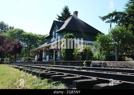 Bahnhofsbahnschienen beherbergen Grünanlagen. Hochwertige 4K-Aufnahmen Stockfoto