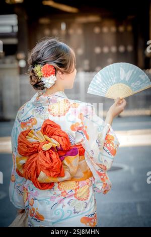 Frau trägt Kimono mit einem Ventilator in der Hand. Kyoto, Japan. Traditioneller japanischer Hintergrund. Stockfoto