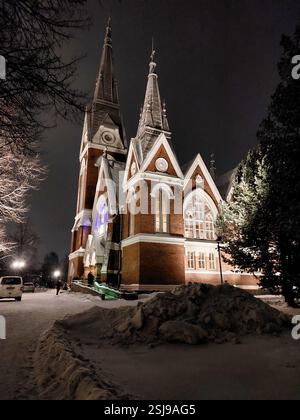 Die Joensuu-Kirche, ein atemberaubendes neogotisches Gebäude, wunderschön beleuchtet in einer verschneiten Winternacht in Joensuu, Finnland. Stockfoto
