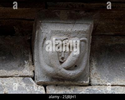 Modillion der romanischen Kirche unserer Lieben Frau von der Himmelfahrt in Jou-sous-Monjou, Kantal, Frankreich. Stockfoto