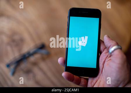 Ein Mobiltelefon wird gehalten und zeigt die Deliveroo App auf dem Bildschirm an. Foto: SMP News Stockfoto