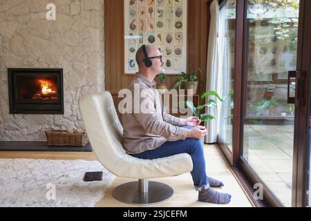 Mann sitzt im Sessel und meditiert Stockfoto