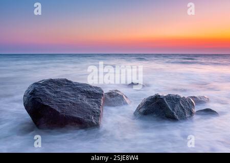 Große Felsbrocken im Surfen am Brodtener Ufer / Brodten Steilufer, Klippe in der Lübecker Bucht an der Ostsee bei Sonnenaufgang, Schleswig-Holstein, Deutschland Stockfoto