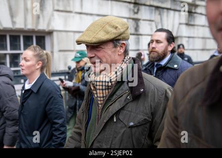 Der Abgeordnete von Clacton und Nigel Farage, der Vorsitzende der Reformpartei, läuft durch eine Demonstration, während er von der Sicherheitsbehörde begleitet wird. Die Landwirte nehmen an dem jüngsten Protest gegen die Reformen der britischen Regierung in der Erbschaftssteuer Teil. Organisiert von der Pressure Group Save British Farming und unterstützt von Nigel Farages Reformpartei, wurde der Konvoi der Traktoren in London während der Morgenstunden gesehen, bevor er Westminster für eine Demonstration in Whitehall betrat. Stockfoto